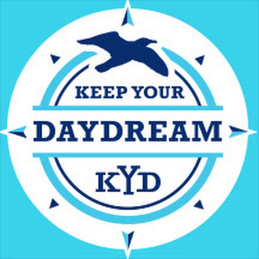 Logo for 'Keep Your Daydream' featuring a bird silhouette and compass design, with the text 'Keep Your Daydream' above and the acronym 'KYD' below, all set against a light blue background.